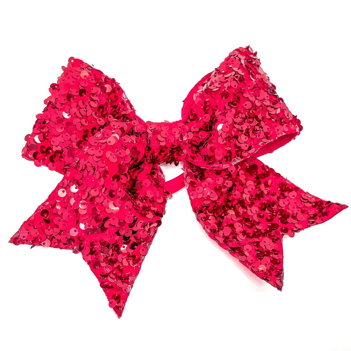 Large pink sequin bow on a white background