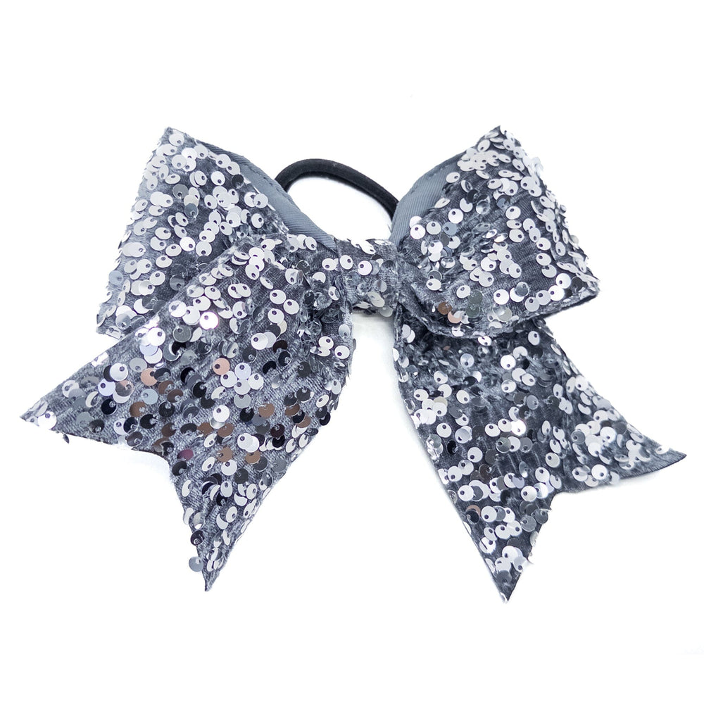 Gray sequin bow with a black hair tie on a white background