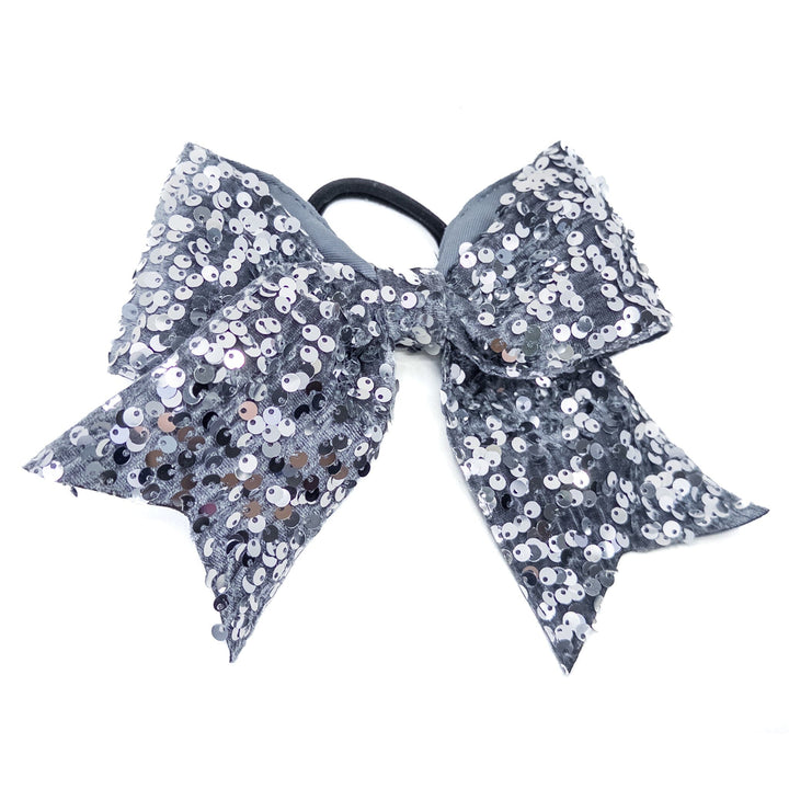 Gray sequin bow with a black hair tie on a white background