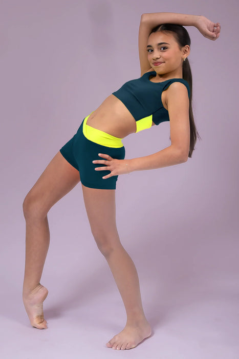 Dancer in a green and yellow leotard posing against a light purple background