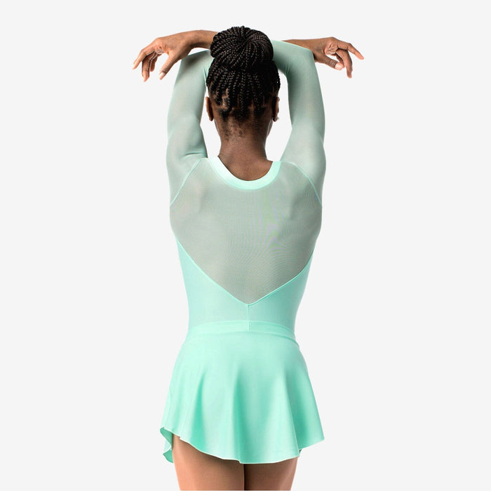 Person wearing a light green and gray dress with arms raised on a white background