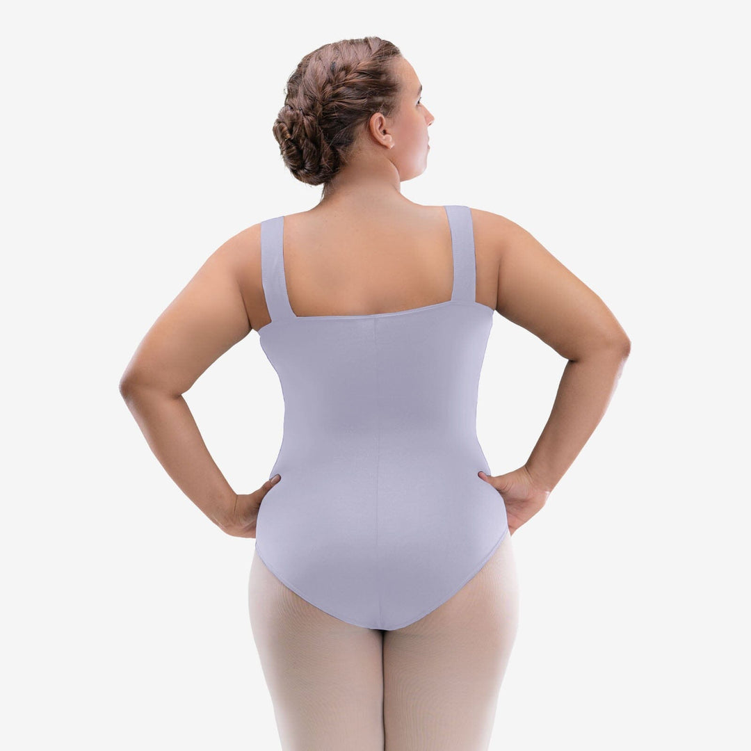 Woman wearing a light gray bodysuit on a white background