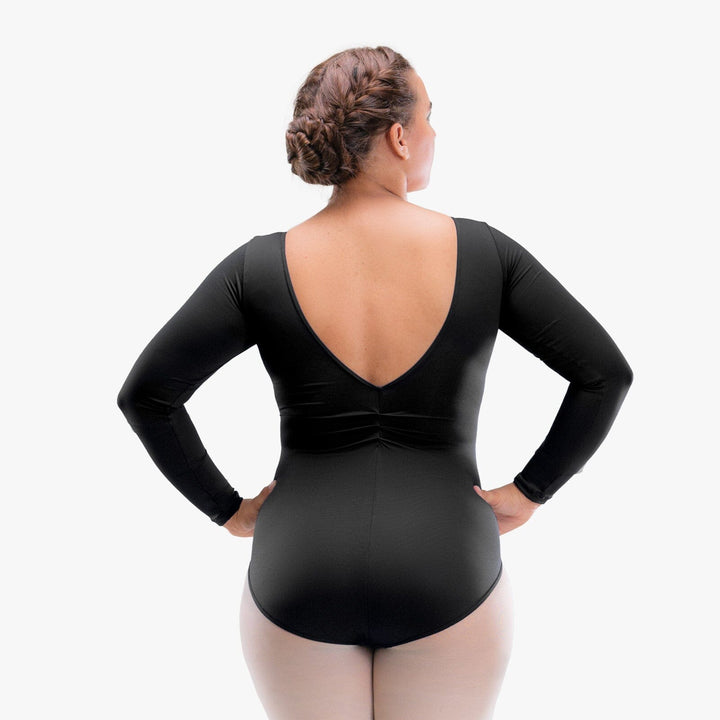 Person wearing a black bodysuit with long sleeves on a white background
