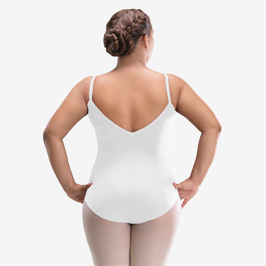 Woman wearing a white bodysuit against a plain background