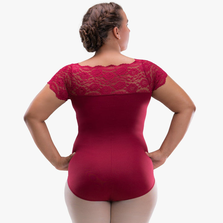 Woman wearing a red bodysuit with lace detailing on a white background