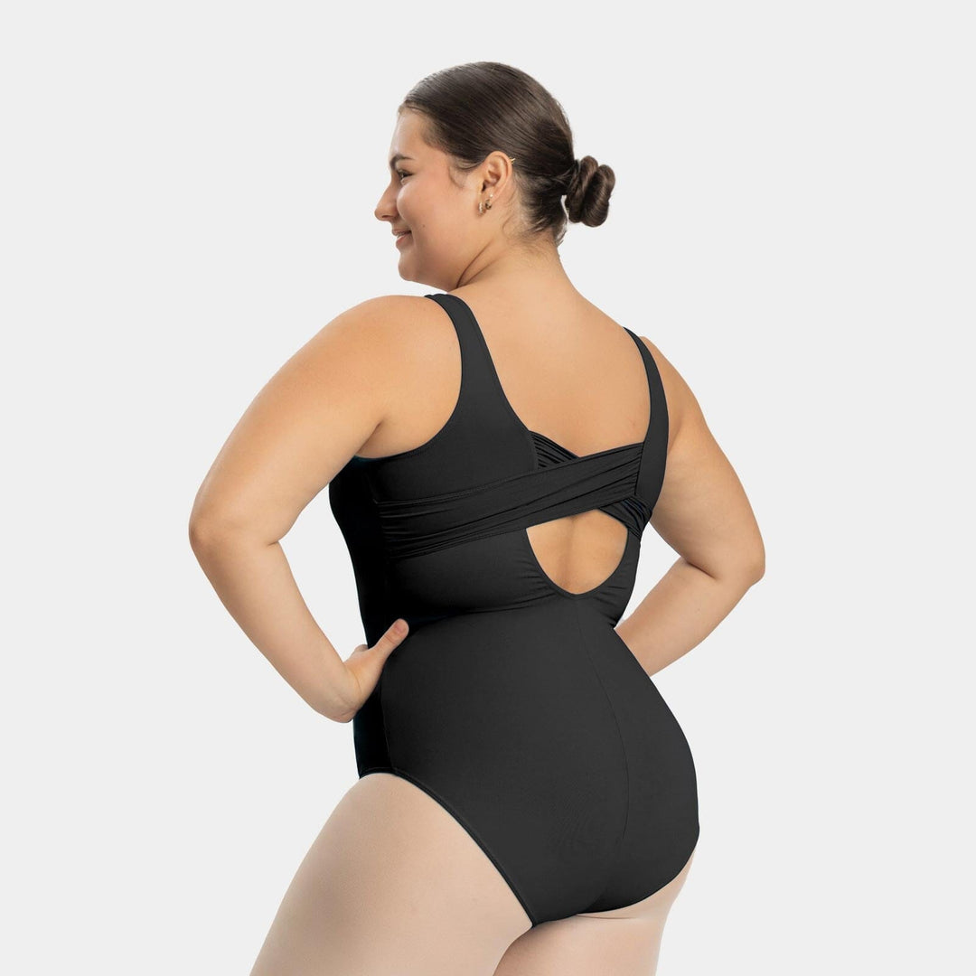 Woman wearing a black swimsuit with cut-out design on a light gray background