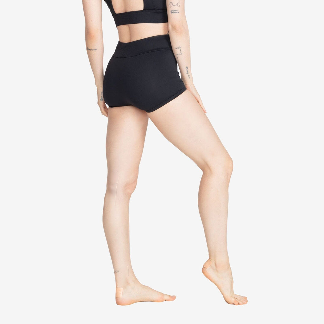 Person wearing black high-waisted shorts on a white background