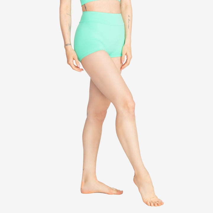 Person wearing a mint green high-waisted bikini bottom on a white background