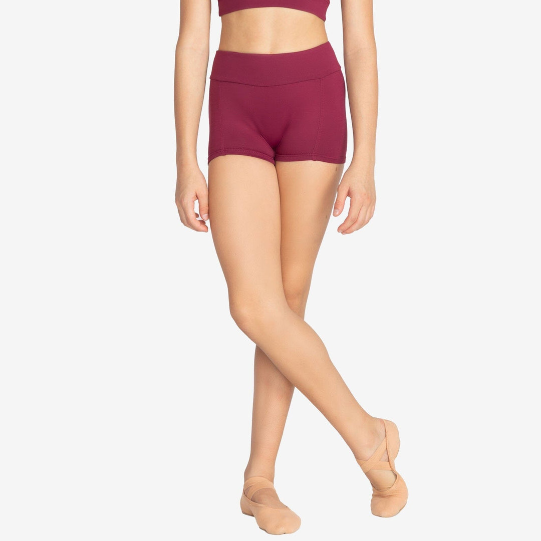 Person wearing maroon high-waisted shorts on a plain background