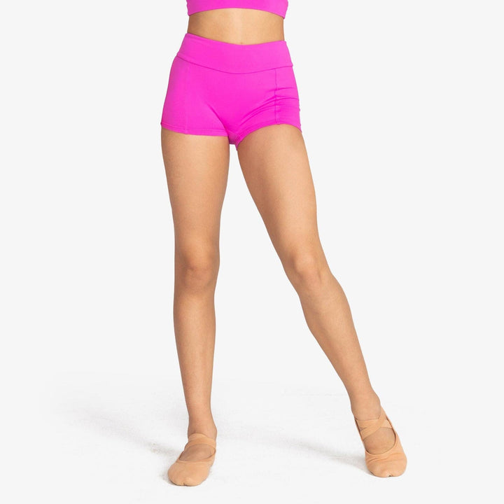 Person wearing bright pink high-waisted shorts on a white background