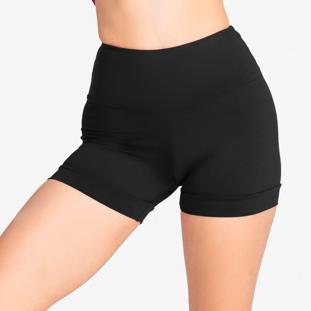 Black athletic shorts worn by a person on a plain background