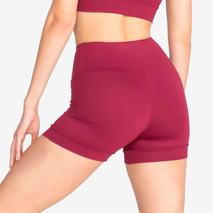 Maroon athletic shorts worn by a person on a light gray background