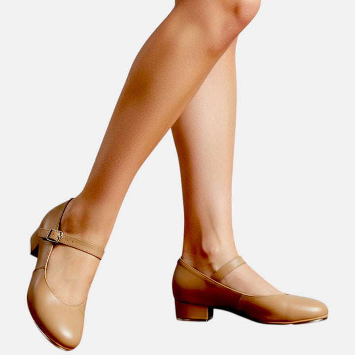 Tan shoes worn with beige tights on a light gray background