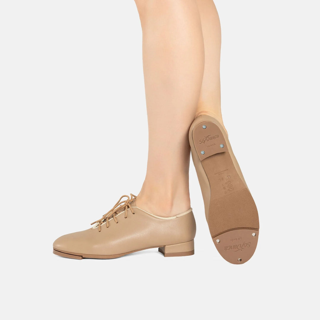 Beige tap shoes worn with beige tights on a white background