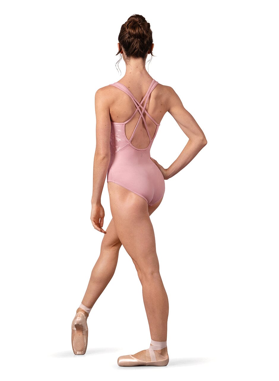 Ballerina in a pink leotard and ballet shoes on a white background