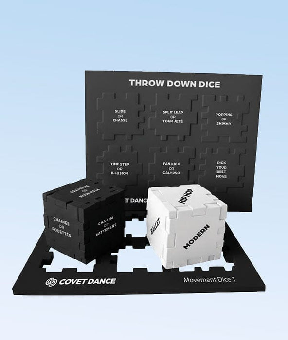 Dance movement dice set with black and white dice on a branded mat against a light blue background