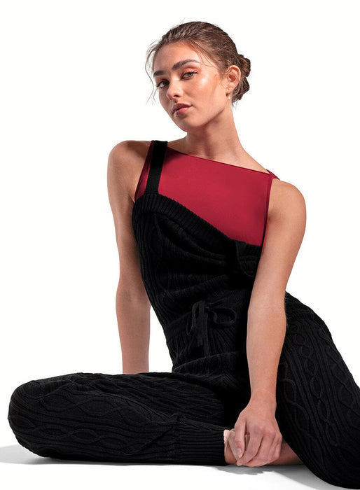 Woman wearing a black and red dress sitting on a white background