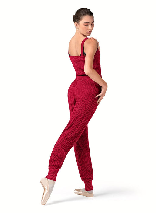 Woman wearing a red ribbed jumpsuit on a white background