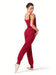 Woman wearing a red ribbed jumpsuit on a white background