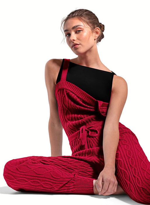 Woman wearing a black and red dress sitting on the floor against a white background