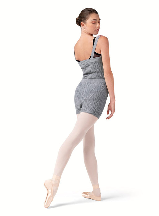 Dancer wearing a gray knit dress and beige tights on a white background