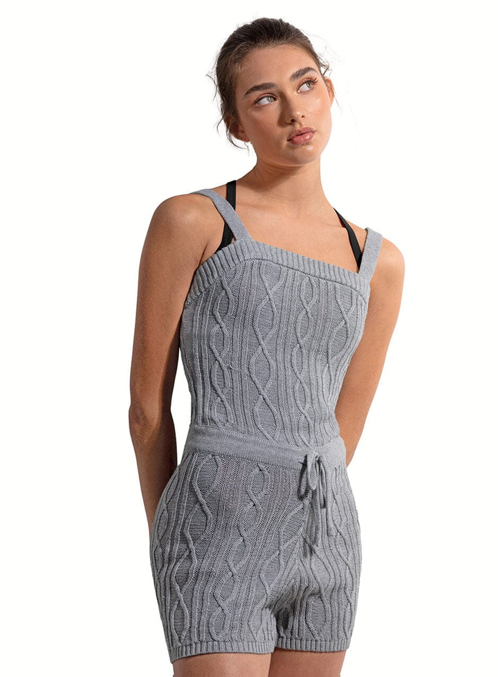Woman wearing a gray knitted romper on a white background
