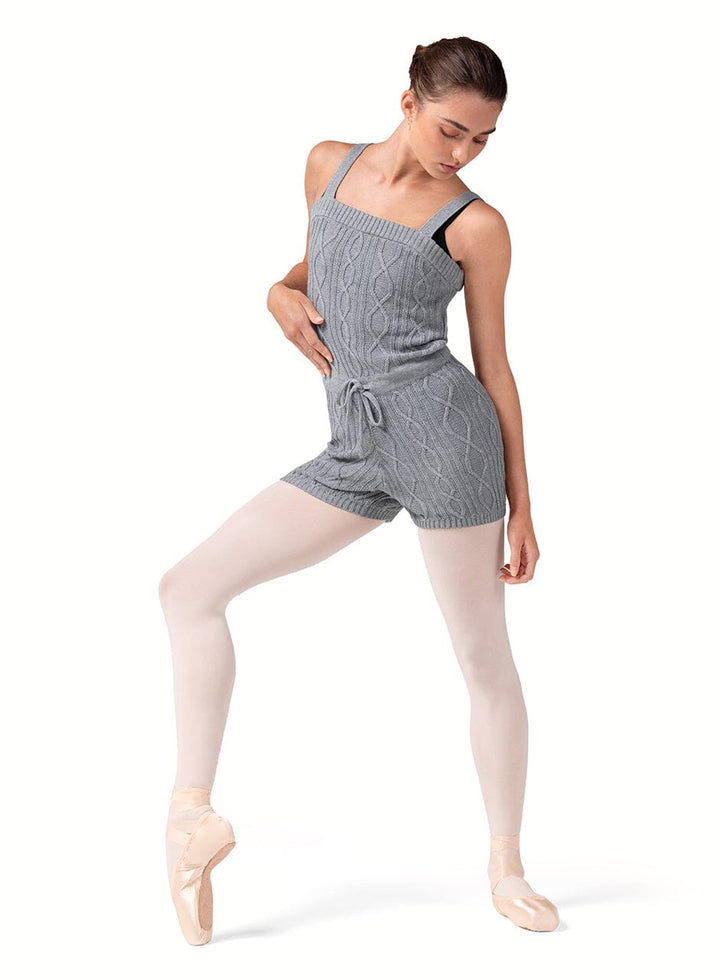 Dancer in a gray romper with white tights on a white background
