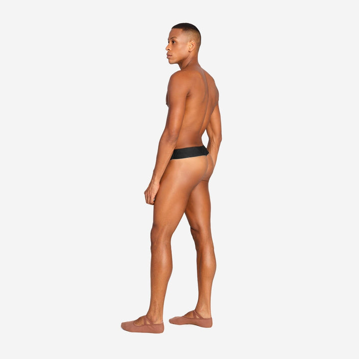 Man wearing a black thong on a white background