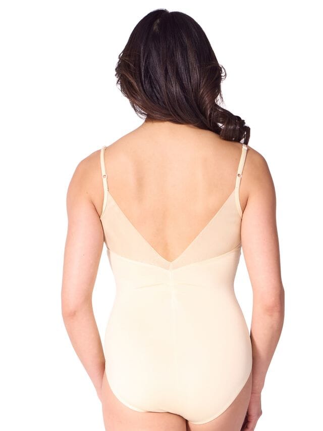 Woman wearing a beige bodysuit on a white background