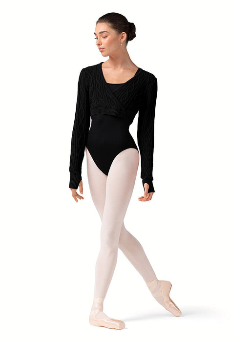 Ballerina in a black leotard and cardigan with beige tights on a white background