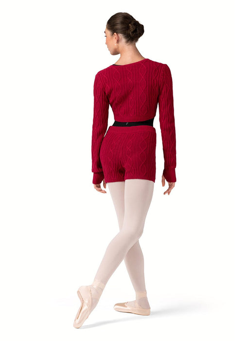 Ballerina in a red outfit with beige tights on a white background