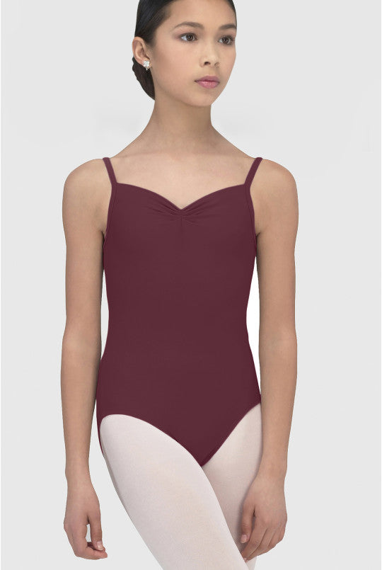 Ballerina wearing a burgundy leotard and white tights on a plain background