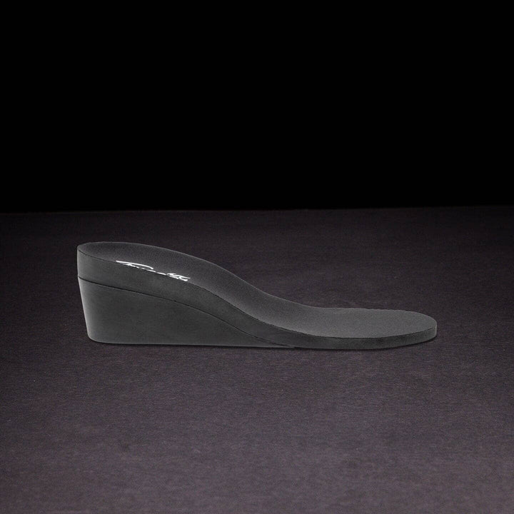 Black wedge shoe on a dark background