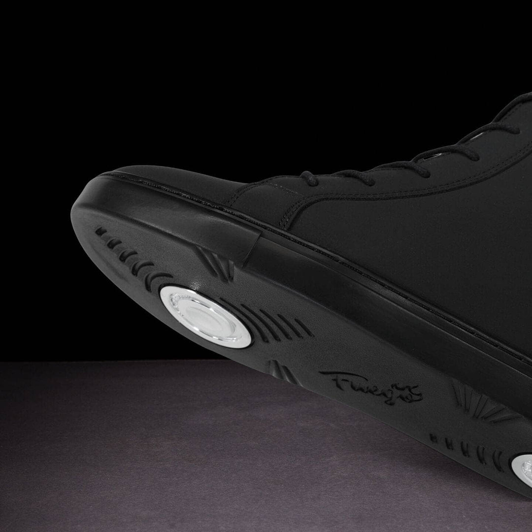 Black sneaker with sole design on a dark background
