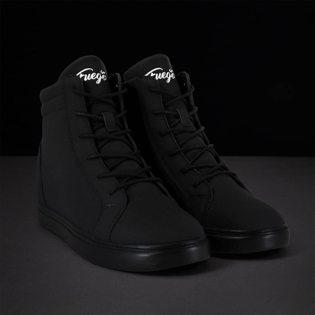 Pair of black high-top sneakers with white logo on a dark background