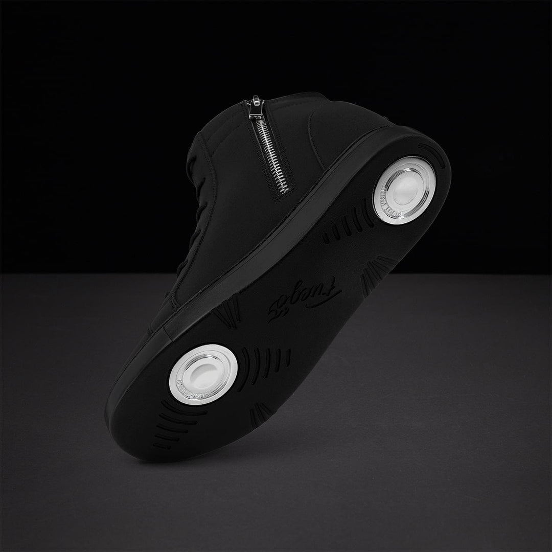 Black sneaker with white sole on a dark background