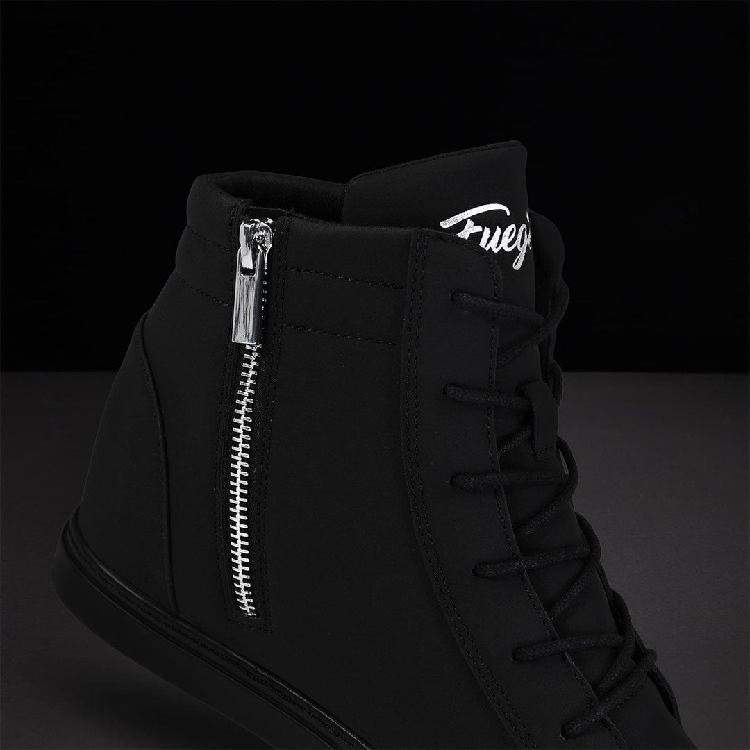 Black high-top sneaker with silver zipper and logo on a dark background