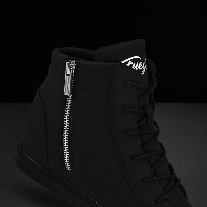 Black high-top sneaker with silver zipper and logo on a dark background