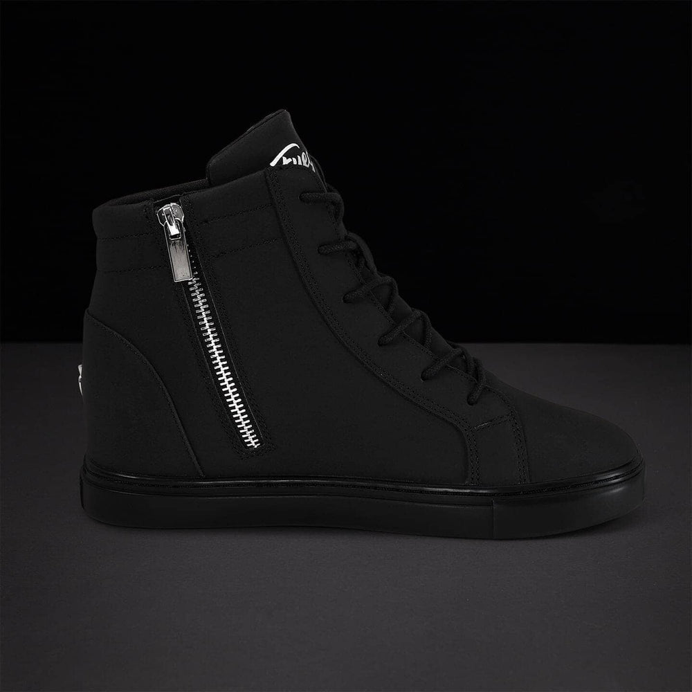 Black high-top sneaker with silver zipper on a dark background