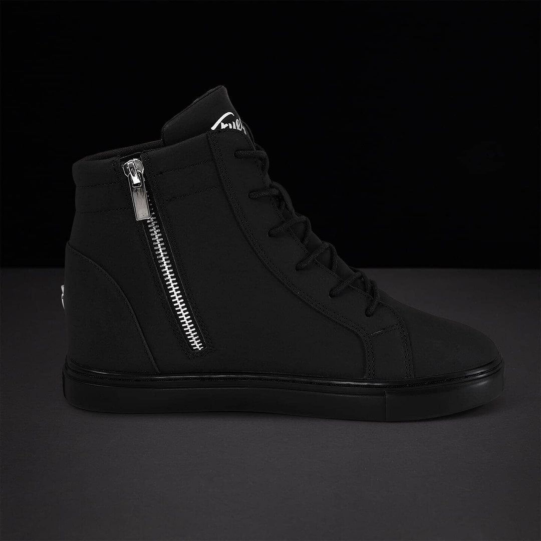 Black high-top sneaker with silver zipper on a dark background
