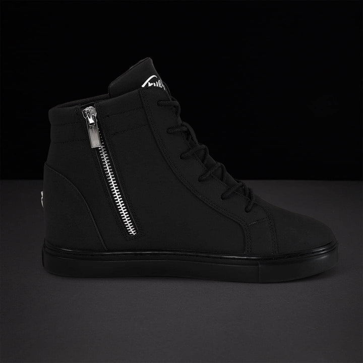 Black high-top sneaker with silver zipper on a dark background