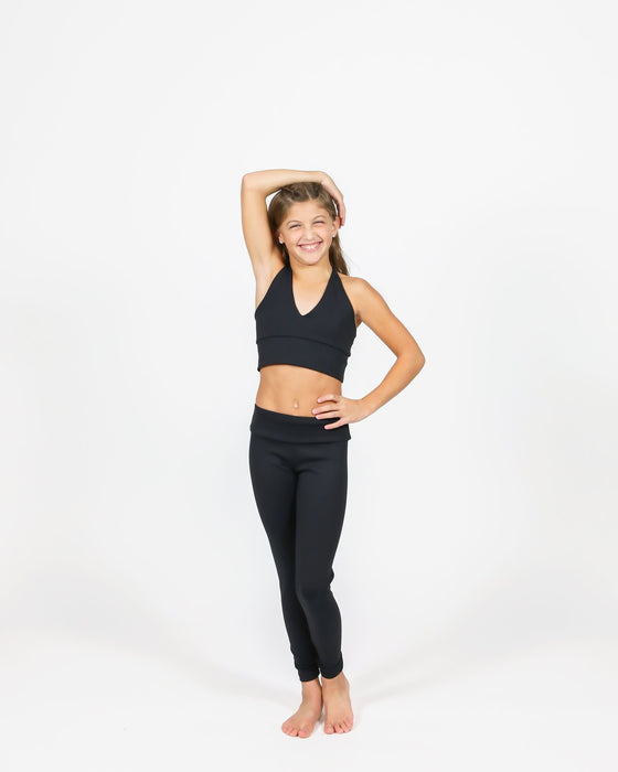 Person wearing a black sports bra and leggings on a white background