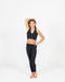 Person wearing a black sports bra and leggings on a white background