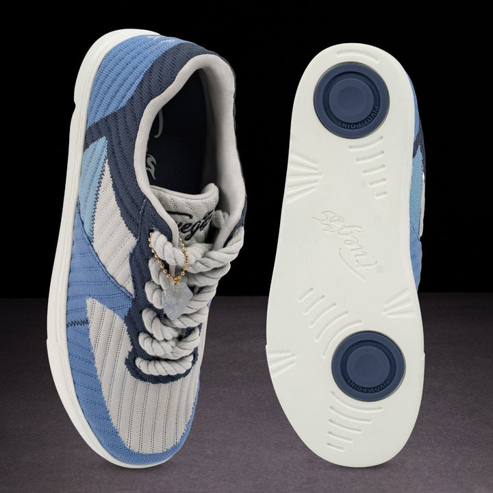 Blue and gray sneaker with white sole on a dark background