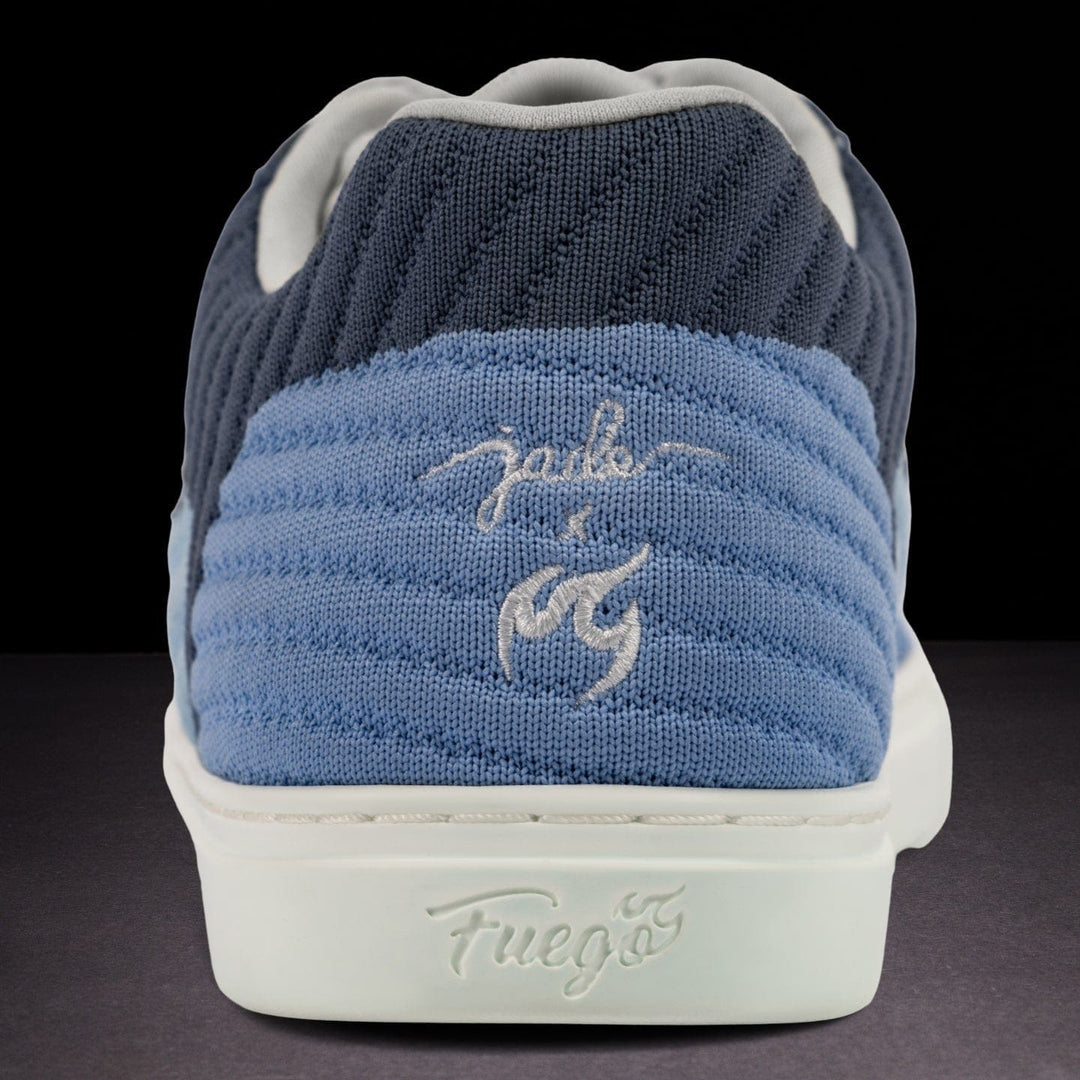 Blue sneaker with white sole on a dark background
