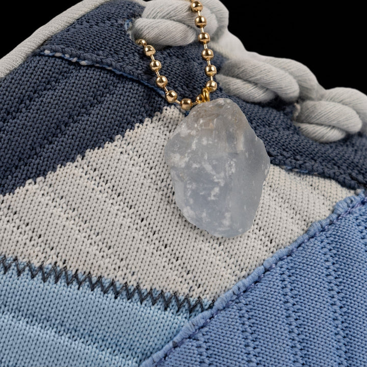 Necklace with a stone pendant on a textured fabric background