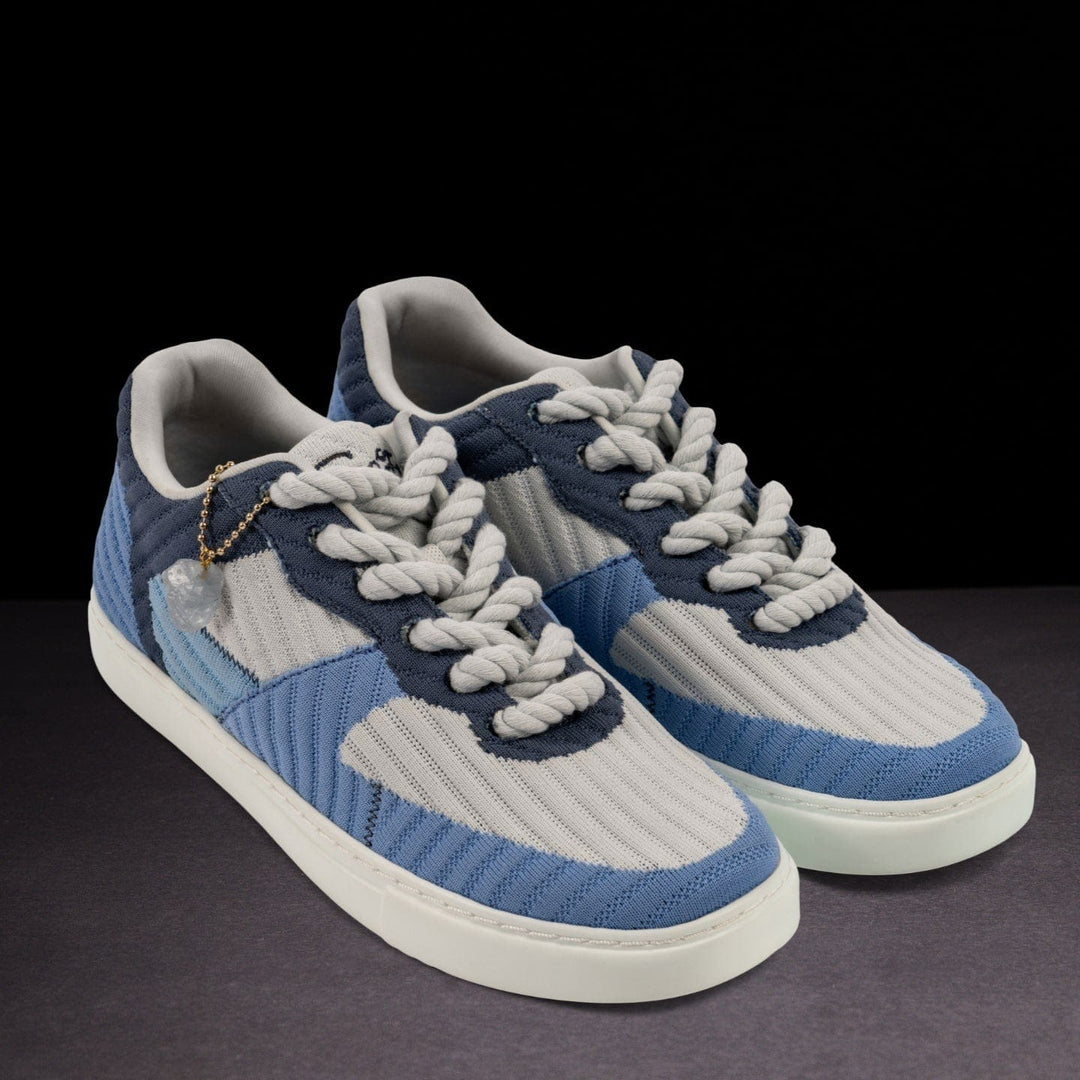 Blue and gray sneakers with braided laces on a dark background