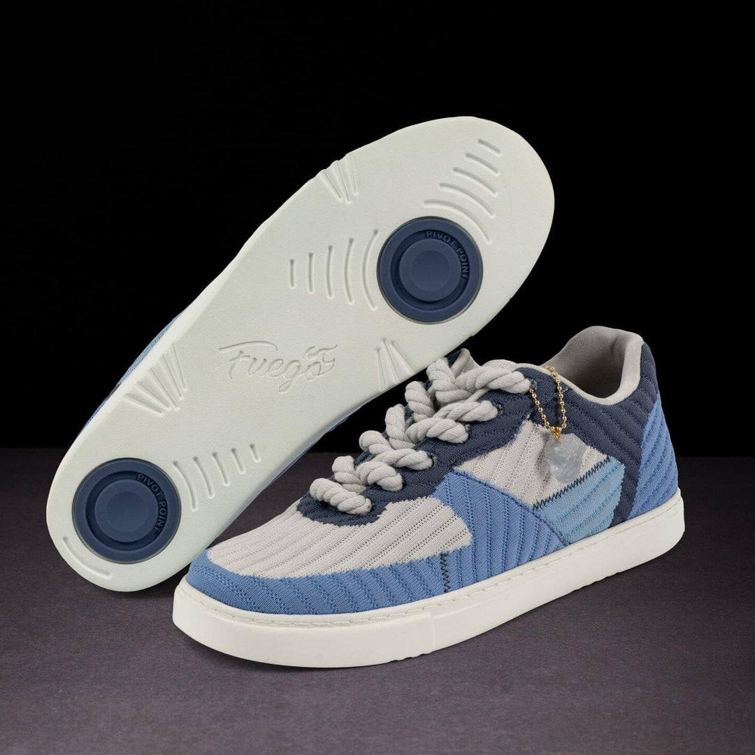 Blue and gray sneaker with white sole on a dark background