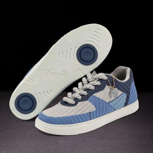 Blue and gray sneaker with white sole on a dark background