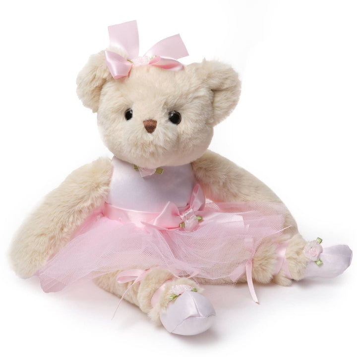 Plush teddy bear in a pink ballet outfit with a bow on a white background